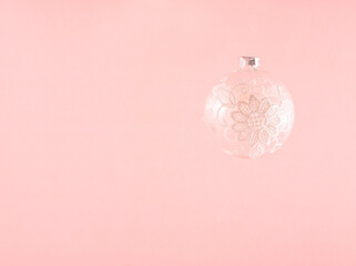 Minimal pastel Christmas composition, transparent, lacy decorative bauble against bright pink background. Greeting card, copy space