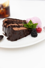 Chocolate cake on a white plate with violet ice cream