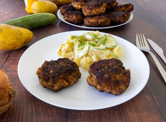 German meatballs called Frikadellen served with cucumber potato salad