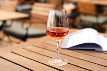 Aperol glass on a table in an outdoor cafe. Vacation and celebration concept. Close-up. Copy space.