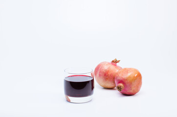 Ripe pomegranates with glass of pomegranate juice on white background healthy life concept