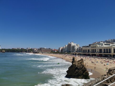 Alguns banhistas na praia de Biaritz com parte da cidade ao fundo