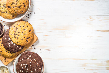 Giant cookies with chocolate chips at wooden table. White and chocolate cookies. Trendy sweetness.