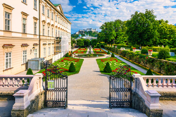 Fototapeta premium Beautiful view of famous Mirabell Gardens with the old historic Fortress Hohensalzburg in the background in Salzburg, Austria. Famous Mirabell Gardens with historic Fortress in Salzburg, Austria.
