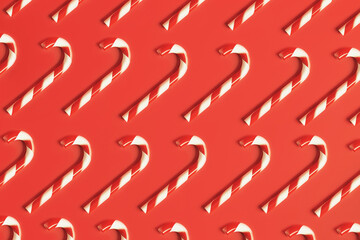 Traditional sweet candy cane Christmas new year cookies, flat lay pattern on red background