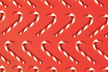 Traditional sweet candy cane Christmas new year cookies, flat lay pattern on red background