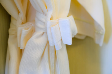 white bathrobe hanging in closet - obrazy, fototapety, plakaty