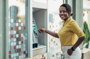 African american woman using an atm machine and a credit card