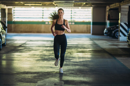 Attractive young woman running while training outside