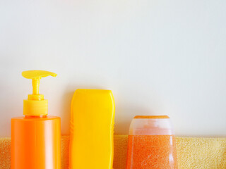 Bottles with shower gel, shampoo yellow and orange top view place for text and copy.