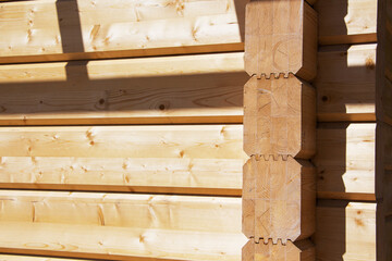 Fragment of a construction built of glued pine timber beams.