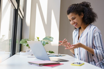 Confident smiling African American businesswoman using laptop computer having video call sitting in...