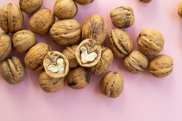 Walnuts heart shaped on pink background
