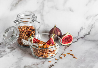 Delicious healthy breakfast - greek yogurt with homemade granola and figs on a light background,...