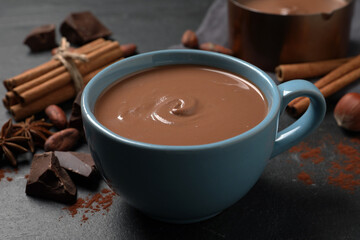 Yummy hot chocolate in cup on black table