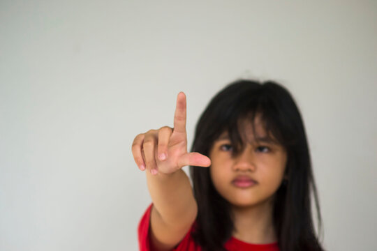 A young beautiful girl pointing with her index finger.