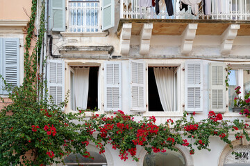 Fototapeta na wymiar open wooden shutters, flowers, typical greek architecture