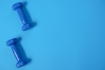 fitness sport concept. Blue dumbbells on Blue background. Sport equipment background for healthy