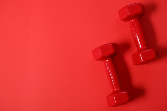 Fitness Sport Concept. Red Dumbbells On Red Background. Sport Equipment Background For Healthy