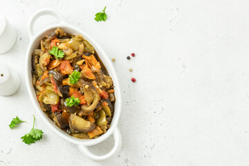 Roasted vegetables spicy  saute in baking dish. Space for text, top view