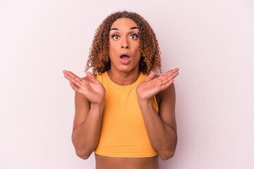 Young latin transsexual woman isolated on pink background surprised and shocked.