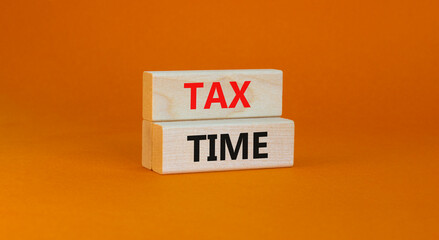 Tax time symbol. Concept words Tax time on wooden blocks on a beautiful orange background. Business and tax time concept. Copy space.