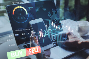 Close up of hands using laptop and smartphone with forex chart and sell, buy buttons on blurry background. Stock exchange, cryptocurrency and global fund information concept. Double exposure.