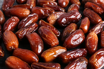 Many sweet dried dates on dark grey background, closeup