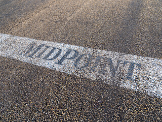 Midpoint sign painted on the Route 66 pavement at the halfway point between Chicago and Los Angeles in Adrian Texas.