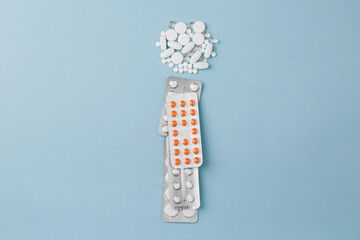 Letter I from medical pills, blisters, syringe and vaccine vial on blue background. Pharmaceutical...