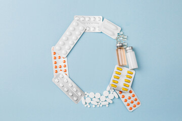 Letter Q from medical pills, blisters, syringe and vaccine vial on blue background. Pharmaceutical alphabet. Complex therapy. 