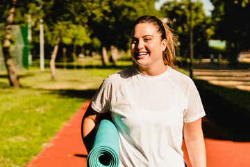 Close up portrait of a smiling body positive young caucasian plump fat plus-size woman athlete in...