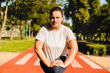 Caucasian young fit plus-size plump woman athlete stretching doing yoga exercises losing weight...
