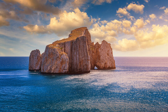 High cliffs of Mediterranean coast, "Pan di Zucchero" stack rock in Masua, west coast of Sardinia, Italy. Concali su terrainu a limestone formation in southern Sardinia, Italy.
