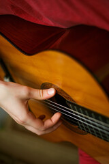 Fototapeta premium Kids hands on guitar strings. Playing guitar