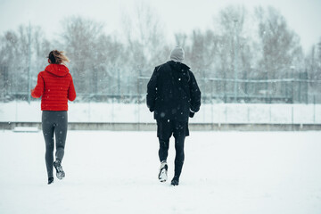 Young couple going for a run together during a snow