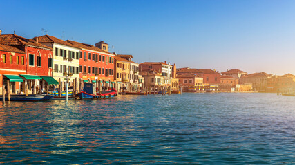 Fototapeta na wymiar Murano glass making island, water canal, bridge, boat and traditional buildings. Venice or Venezia, Italy, Europe.