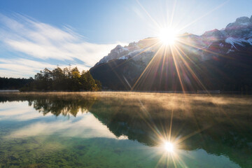 Mountain Zugspitze and lake eibsee at sunrise in autumn with fall colors. Hiking in Bavaria in the...