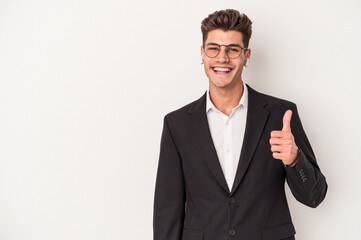 Young business caucasian man wearing headphones isolated on white background smiling and raising thumb up