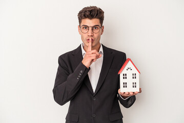 Young real estate caucasian agent isolated on white background keeping a secret or asking for...
