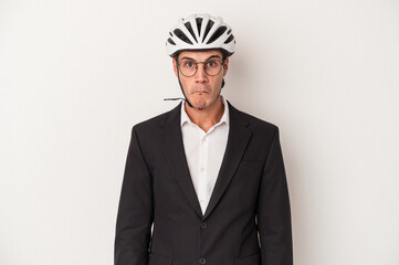 Young business caucasian man holding bike helmet isolated on white background shrugs shoulders and...