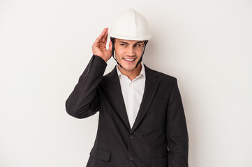 Young architect caucasian man isolated on white background trying to listening a gossip.