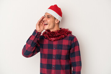 Young caucasian man celebrating Christmas isolated on white background shouting and holding palm near opened mouth.