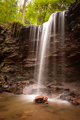 Obraz premium Waterfall cascade flowing over a rock