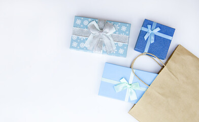 Fototapeta na wymiar Blue boxes with Christmas gifts and a craft package on a white background. Christmas sale,holiday discounts,New Year background