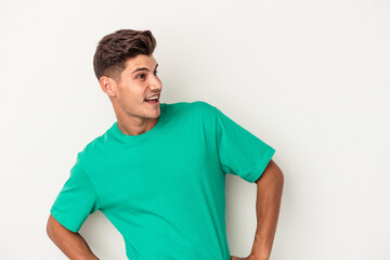 Obraz premium Young caucasian man isolated on white background laughs happily and has fun keeping hands on stomach.