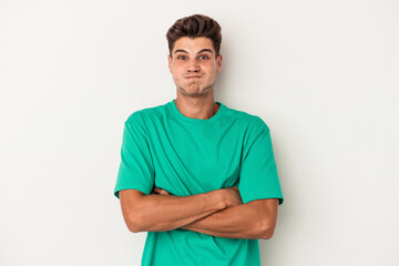 Obraz premium Young caucasian man isolated on white background blows cheeks, has tired expression. Facial expression concept.