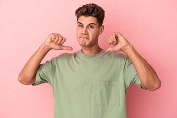 Young caucasian man isolated on pink background feels proud and self confident, example to follow.