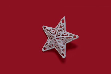 Fototapeta na wymiar Christmas toy star on red background. Minimal Christmas concept