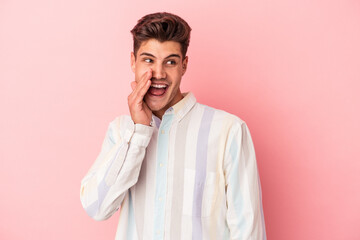 Young caucasian man isolated on pink background shouting excited to front.